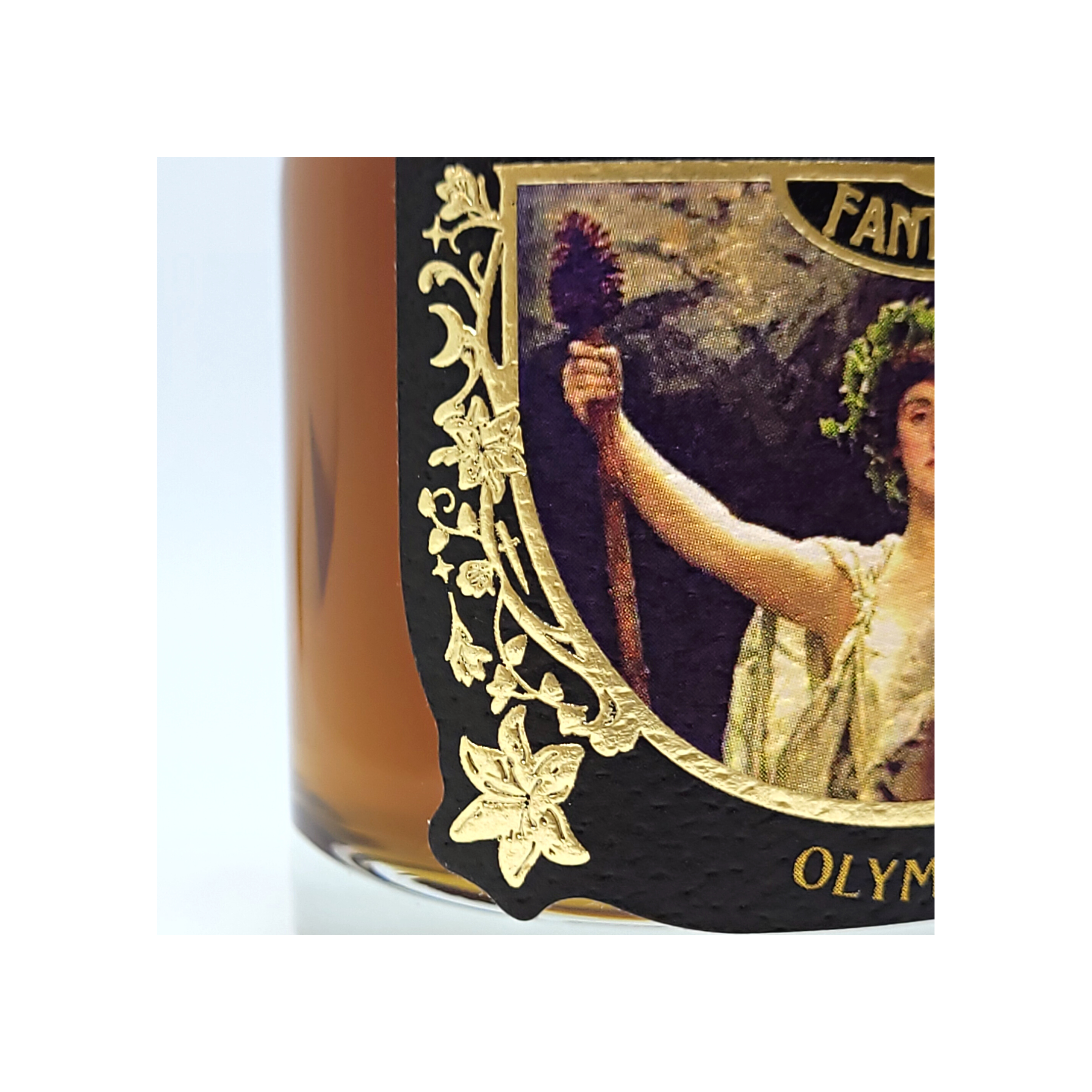 A close up of the label details of the shiny gold embossed filigree. It is art nouveau style with lilies and vines on the matte, color label.