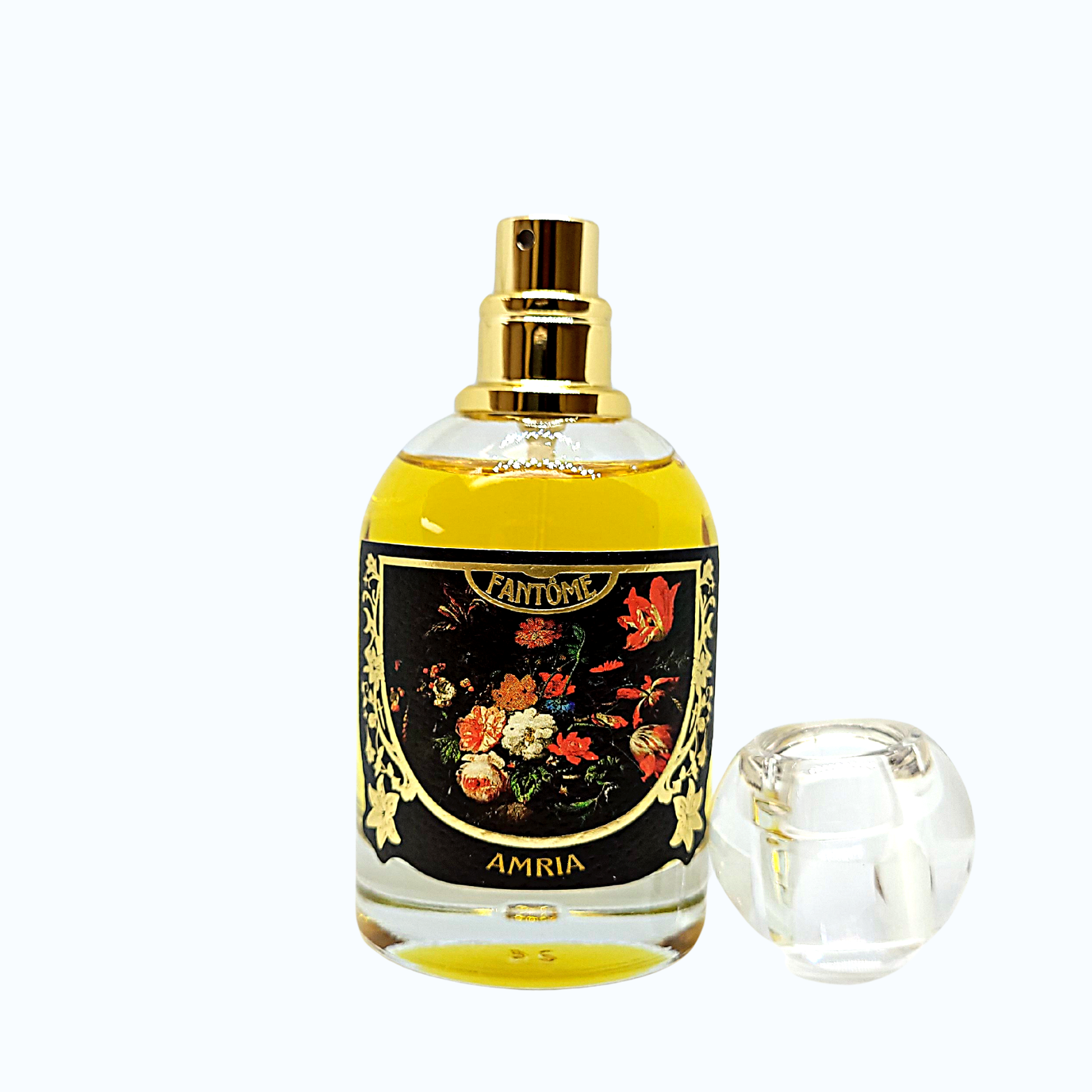 50ml glass bottle of Amria perfume with gold foil embossed label and the circular perfume cap on the side. The gold atomizer with stepped collar is visible. On the label, gothic dark florals are on a black background. The bottle itself is on a white background.